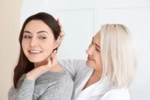 Woman looking at her daughter's new hearing aid